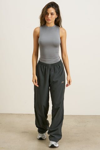 Full body front view of model posing in the fitted shadow modal Refined Tank with a high neckline.  