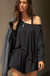Front view of model posing in the relaxed-fit black modal Easy Short with an elastic waistband, side pockets and subtle pleating for added shape and dimension