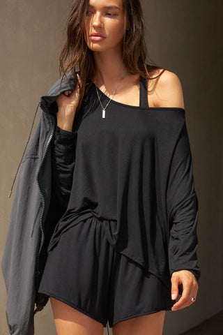 Front view of model posing in the relaxed-fit black modal Easy Short with an elastic waistband, side pockets and subtle pleating for added shape and dimension