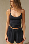Front view of model posing in the fitted blush modal Scoop Neck Cami with thin adjustable straps, scoop neckline and scoop back