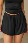 Front view of model from the waist down posing in the relaxed-fit fawn nylon Classic Track Short with an elastic waistband, side seam pockets, and adjustable drawcord.