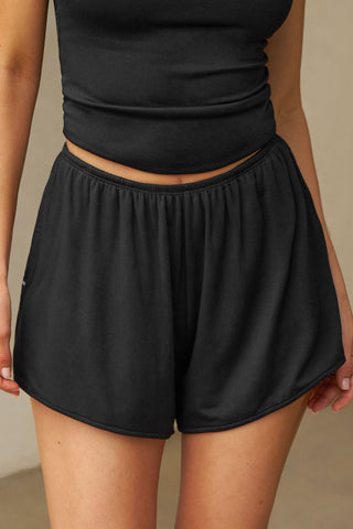 Front view of model from the waist down posing in the relaxed-fit fawn nylon Classic Track Short with an elastic waistband, side seam pockets, and adjustable drawcord.