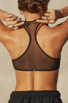 Close up back view of model posing in the sheer black mesh Scoop Neck Racerback Bra with a racerback silhouette