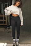 Full body front view of model posing the full length and high-waisted sueded onyx Second Skin Legging with a wide, v-shaped waistband