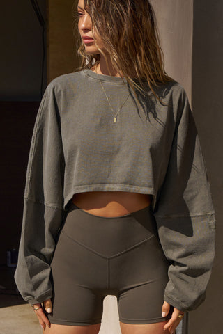 Front view of model posing in the cropped relaxed fit haze cotton Slouchy Crop Long Sleeve top with a crew neckline, dropped shoulders and oversized sleeves
