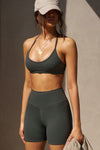 Side view of model posing in the sporty sueded essex T-Back Bra with a scoop neckline, open T-back and adjustable straps.