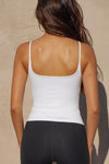 Back view of model posing in the soft and stretchy sueded white Smoothing Cami with a scoop neckline and thin straps