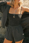 Front view of model posing outside in the relaxed-fit jet nylon Classic Track Short with an elastic waistband, side seam pockets, and adjustable drawcord.