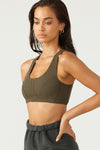 Front view of model posing in the fitted stretchy army flexrib Stitch Bra top with a scoop neckline and stitched detailing at the bust