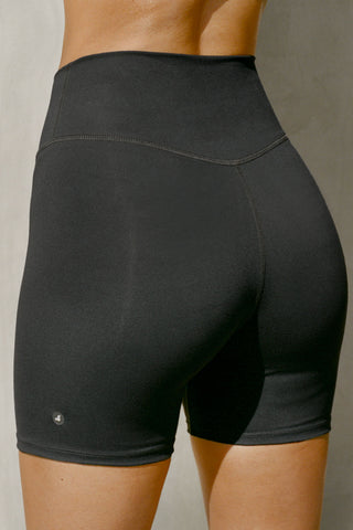 Close up detail back view of model from the waist down posing in the stretch high-waisted sueded onyx 4 Inch Body Short with slimming and contouring wide waistband and 4 inch inseam.