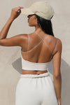 Back view of model posing in the fitted cropped sueded yuma Tri-Layer Corset with an low back and ultra thin corded straps in a cross back design