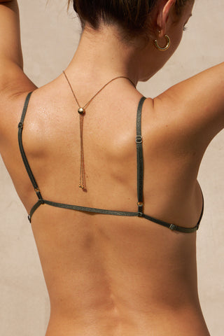 Back view of model posing the sheer, minimal coverage graphite mesh Triangle Bralette with thin and glossy adjustable elastic straps