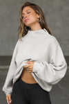 Front view of model posing in the comfortable sahara french terry Turtleneck Sweatshirt pullover with a side split in the collar and a slightly oversized fit