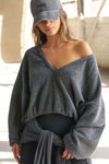Front view of model posing in the slouchy storm sherpa V Neck Pullover sweatshirt with a wide V-neckline that can be worn on or off the shoulders.