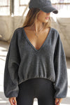 Front view of model posing in the slouchy storm sherpa V Neck Pullover sweatshirt with a wide V-neckline that can be worn on or off the shoulders.