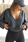 Front view of model posing in the slouchy storm sherpa V Neck Pullover sweatshirt with a wide V-neckline that can be worn on or off the shoulders.