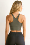 Back view of model posing in the fitted stretchy cropped mineral flexrib Varsity Tank Bra with a racerback silhouette