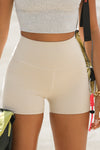 Close up front view of model from the waist down wearing the soft stretchy high-waisted sueded yuma The Body Short with a wide waistband