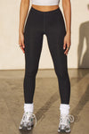 Front view of model from the waist down posing in the sleek and stretchy full length sueded onyx The Body Legging with a mid-rise elastic waistband
