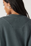 Close up detail back view of model posing in oversized evergreen cotton Vintage Long Sleeve top with a crew neckline and ribbed accents at the upper back