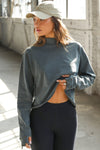 Front view of model wearing the relaxed fit evergreen cotton Vintage Turtleneck Long Sleeve Top with thumbholes and torn seams at the cuff