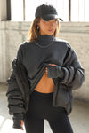 Front view of model wearing the relaxed fit washed black cotton Vintage Turtleneck Long Sleeve Top with thumbholes and torn seams at the cuff