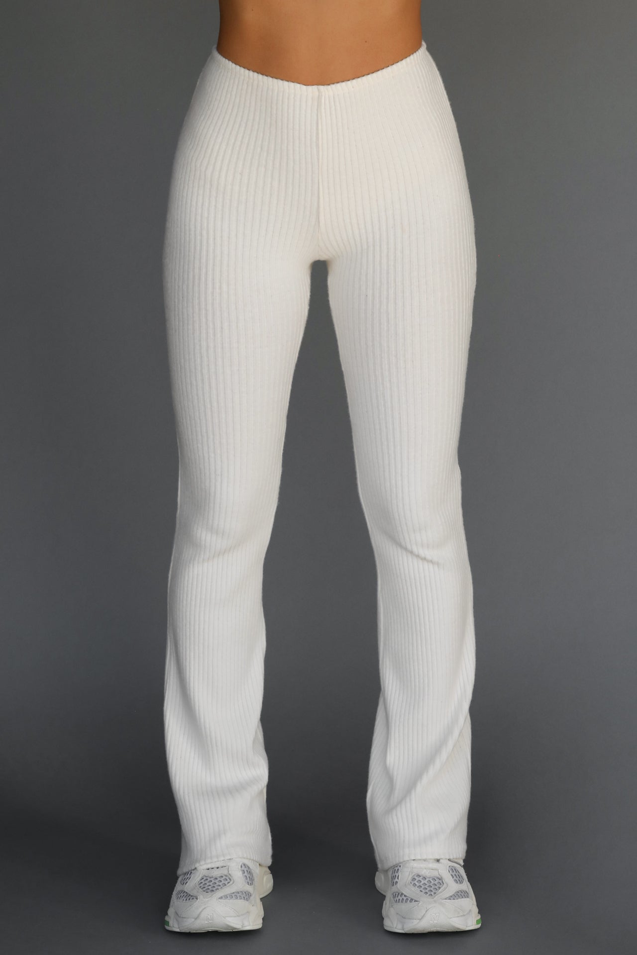 Front view of model from the waist down posing in the mid-rise fitted natural luxe knit Fitted Mini Flare Pant with a slightly flare leg