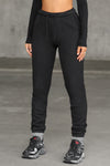Front view of model from the waist down posing in the tapered black french terry Empire Jogger with side pockets and an elastic waistband and ankle cuffs