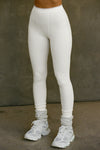 Front view of model from the waist down posing in the stretchy high-waisted bone flexrib Essential Legging with boxer-style stitching, cuffed ankles and an elastic waistband