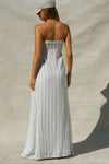 Back view of model posing in the relaxed-fit lightweight natural white and blue stripe gauze Essential Maxi Dress with a straight neckline, fitted bodice and removable adjustable straps 