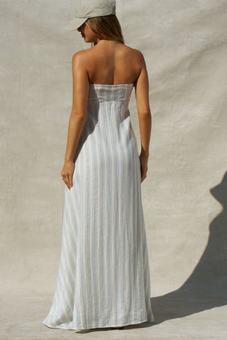 Back view of model posing in the relaxed-fit lightweight natural white and blue stripe gauze Essential Maxi Dress with a straight neckline, fitted bodice and removable adjustable straps 