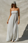 Front view of model posing in the relaxed-fit lightweight natural white and blue stripe gauze Essential Maxi Dress with a straight neckline, fitted bodice and removable adjustable straps 