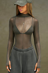 Front view of model posing in the fitted and sheer graphite mesh Exposed Seams Long Sleeve top with a mock neckline and exposed seam details