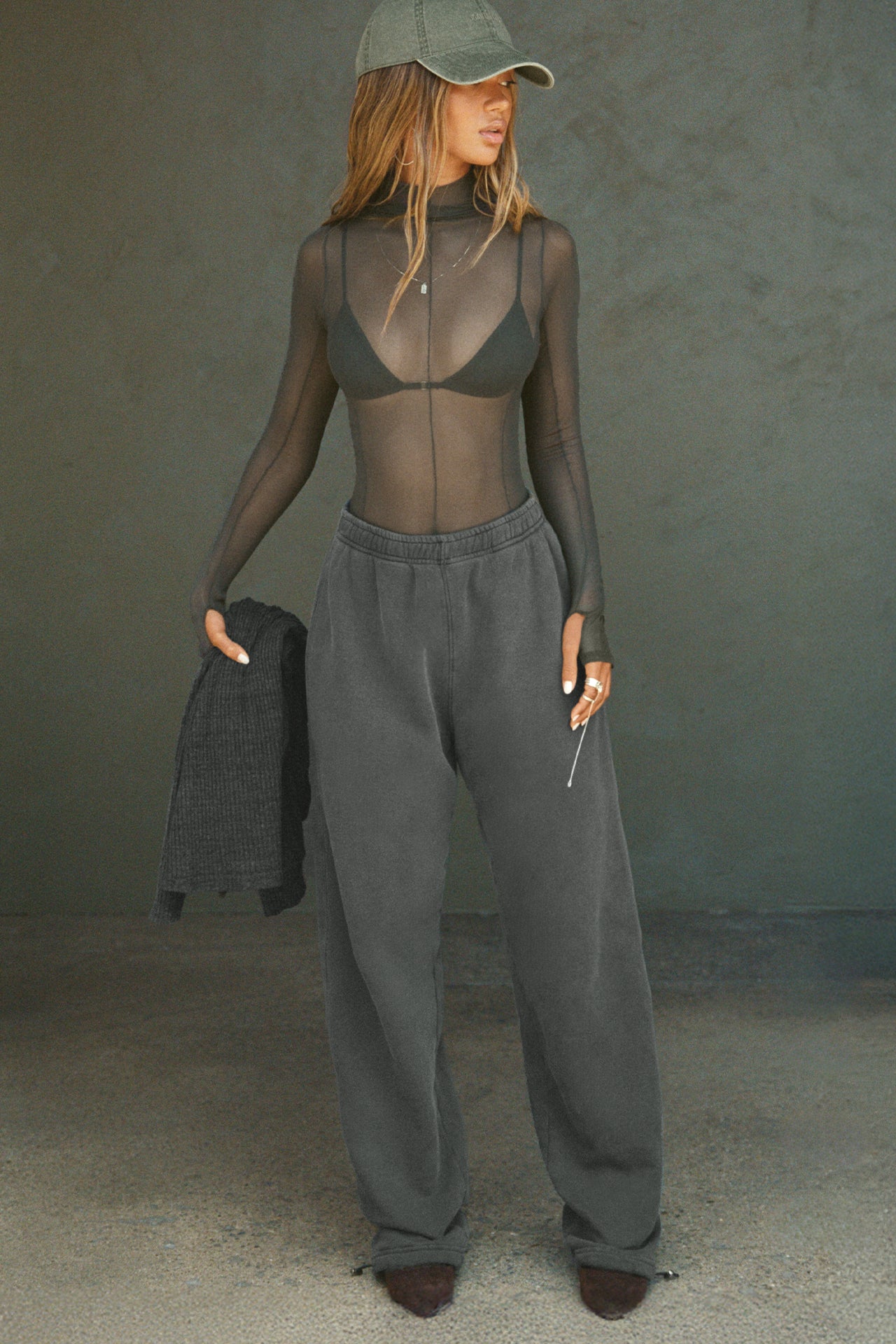 Full body front view of model posing in the fitted and sheer graphite mesh Exposed Seams Long Sleeve top with a mock neckline and exposed seam details