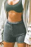 Close up front view of model posing in the high waisted washed black french terry Fitted Sweat Short with an elastic waistband