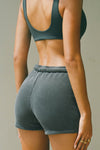 Close up back view of model posing in the high waisted washed black french terry Fitted Sweat Short with an elastic waistband