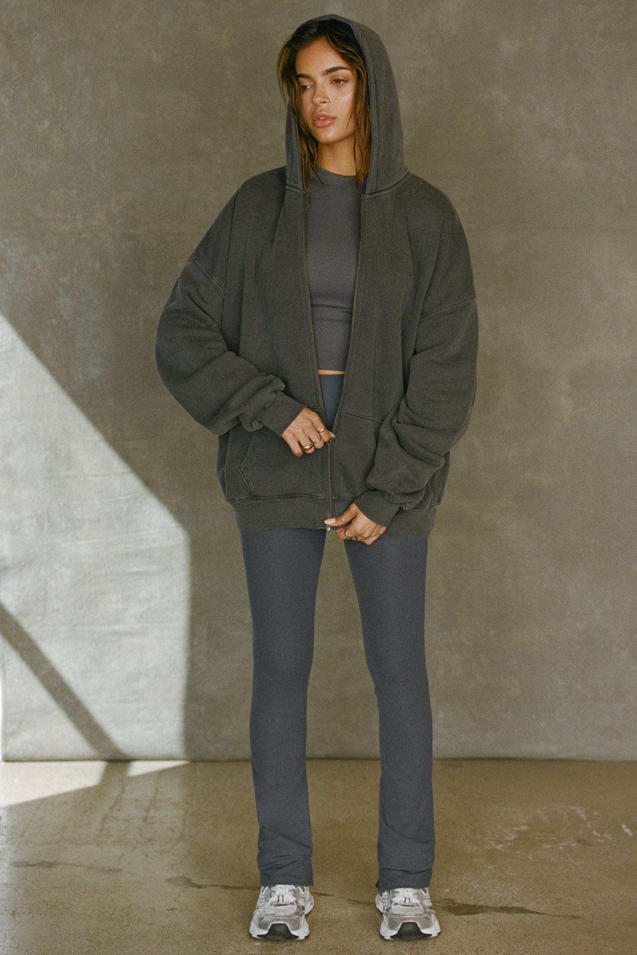 Full body front view of model posing in the full length bootcut sueded navy Second Skin Bootcut Legging with a wide v-shaped waistband and split detail at the leg opening