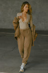 Full body front view of model posing in the oversized loose fit cocoa french terry Oversized Jogger with an elastic waistband and ankle cuffs