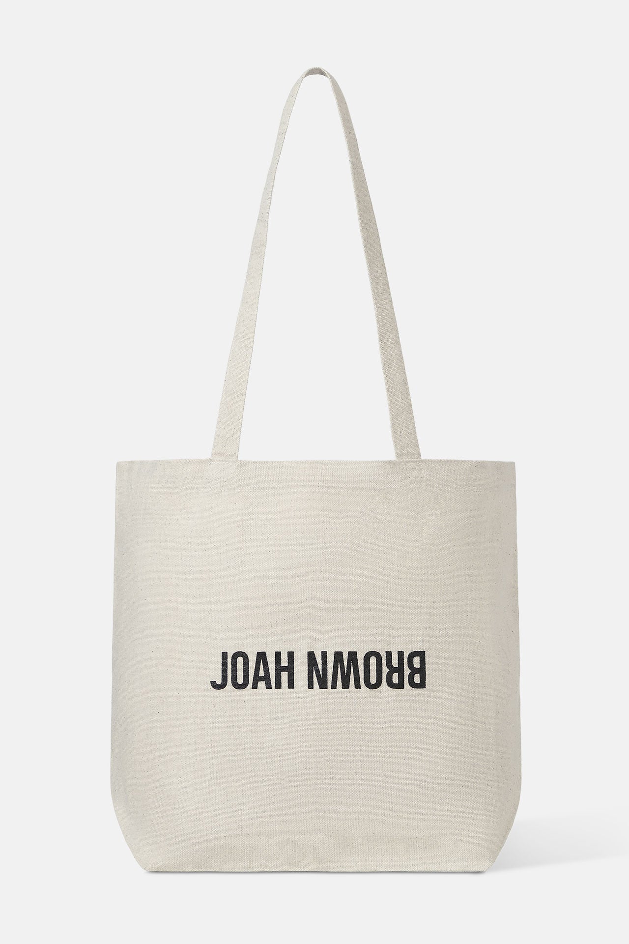 Flat lay front view of the cotton canvas natural Tote Bag with shoulder straps and a black Joah Brown logo on the front