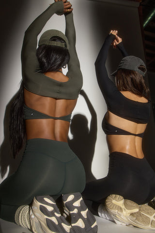 Back view of two models posing in sueded onyx and sueded essex bra and legging sets