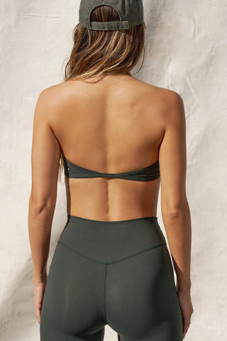 Back view of model posing in the sueded essex Halter Scoop Bra top with an adjustable halter neck strap and open back
