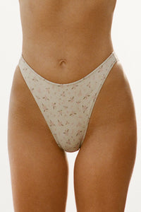 Close up front view of model from the waist down posing in the antique floral High-Waisted Bikini Bottom with a full back coverage bottom and high-cut legs