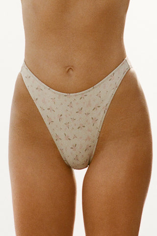 Close up front view of model from the waist down posing in the antique floral High-Waisted Bikini Bottom with a full back coverage bottom and high-cut legs