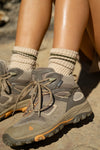 Close up side view of model wearing the oat and olive crew Hiker Sock with ribbed detailing & two thin stripes.