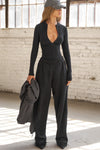Full body front view of model posing in the form fitting black flexrib Invisible Zip Long Sleeve top with a 3/4 front invisible zipper and a crew neckline