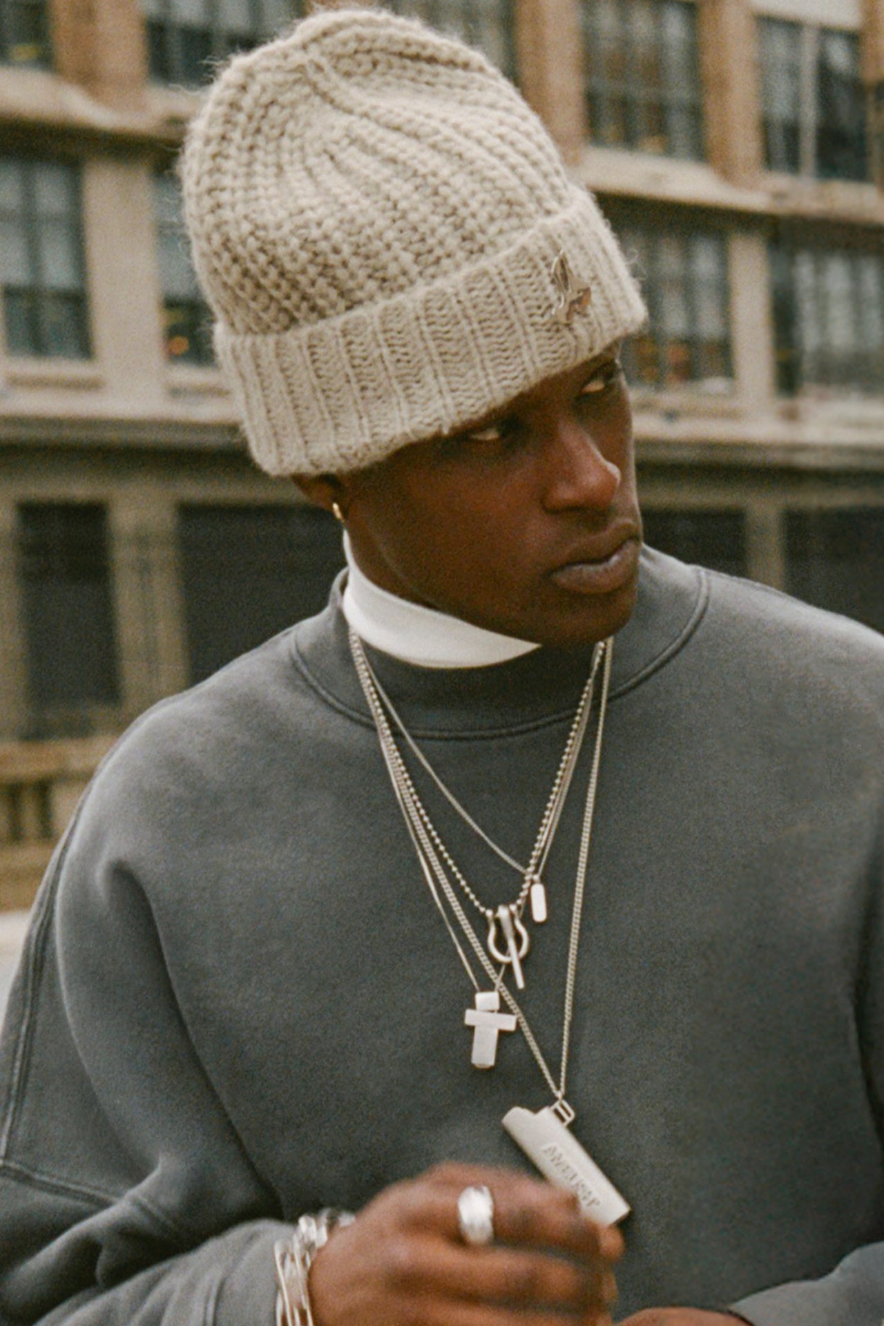 Front view of model posing in the soft and warm oat Knit Beanie that has a removable custom JOAH BROWN pin.