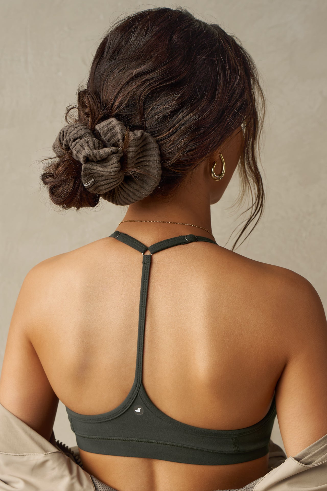 Back view of model wearing the soft and stretchy army luxe knit Knit Scrunchie wrapped around her pony tail