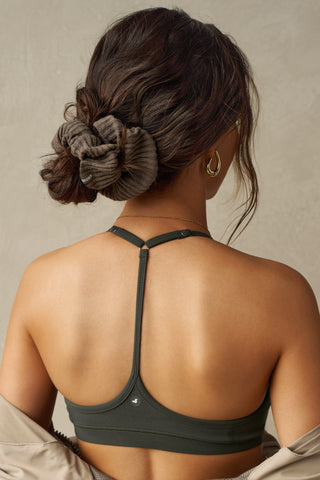 Back view of model wearing the soft and stretchy army luxe knit Knit Scrunchie wrapped around her pony tail
