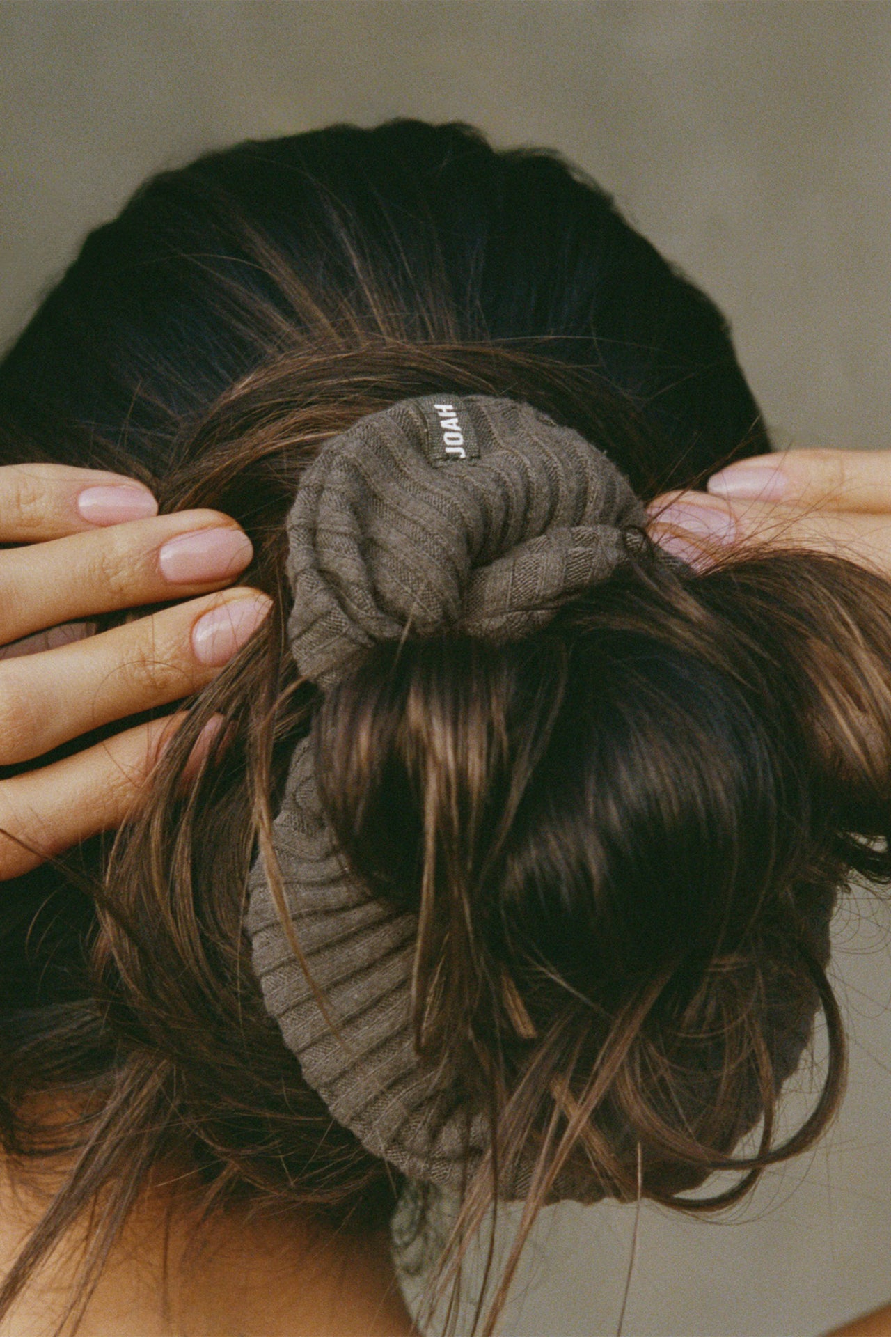 Close up detail back view of model wearing the soft and stretchy army luxe knit Knit Scrunchie wrapped around her pony tail