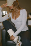 Front view of model posing in the slouchy, pull on natural luxe knit Leg Warmers that can be worn pulled up on scrunched down